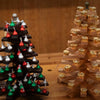 Two kissmas tree beginner woodworking projects on display on a workbench.