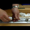 Hands assembling a custom acrylic pen blank on a pen lathe in a workshop setting