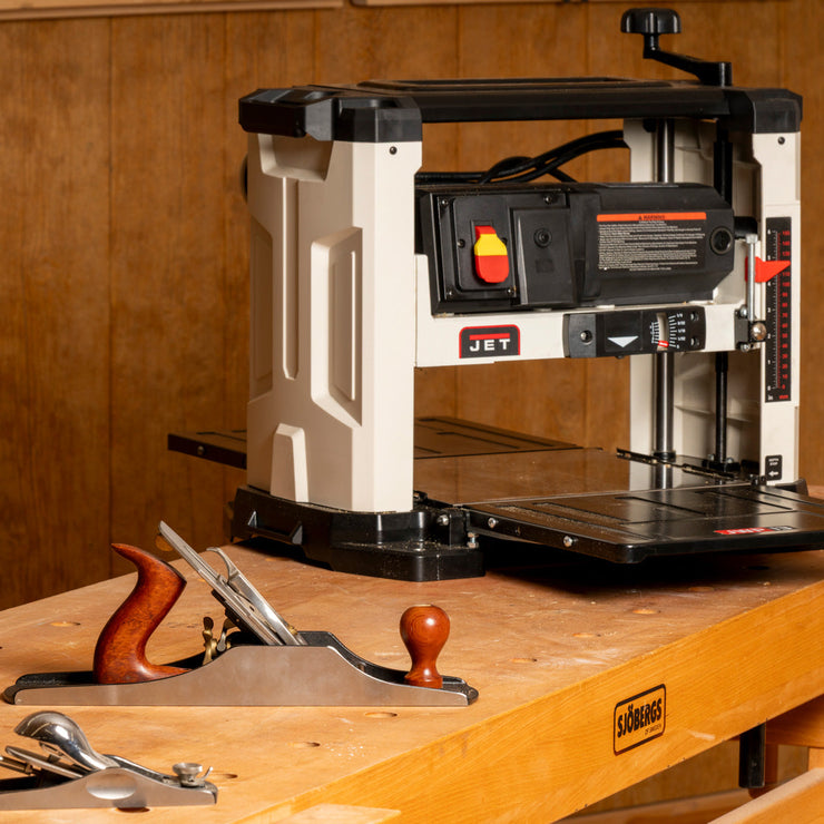 JET benchtop planer and woodworking hand plane on a workbench, showing hand tools and woodworking power tools used in a woodshop