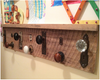 Wall-mounted coat rack made from reclaimed wood with assorted vintage door knobs and handles as hooks.