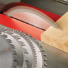 Circular saw blade cutting a hardwood board on a table saw with additional blades nearby