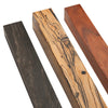 Three wood blanks showing ebony, spalted wood, and reddish hardwood grain patterns for woodworking.