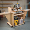 Mobile miter saw stand with mounted saw, extension wings, and storage shelf on casters