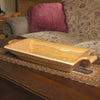 Hand-carved rustic wooden dough bowl with handles on a wooden table runner