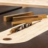 Router plane cutting a smooth groove in light wood with brass weights nearby