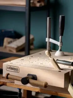 Woodworking tool set on a workbench with a blue wall background