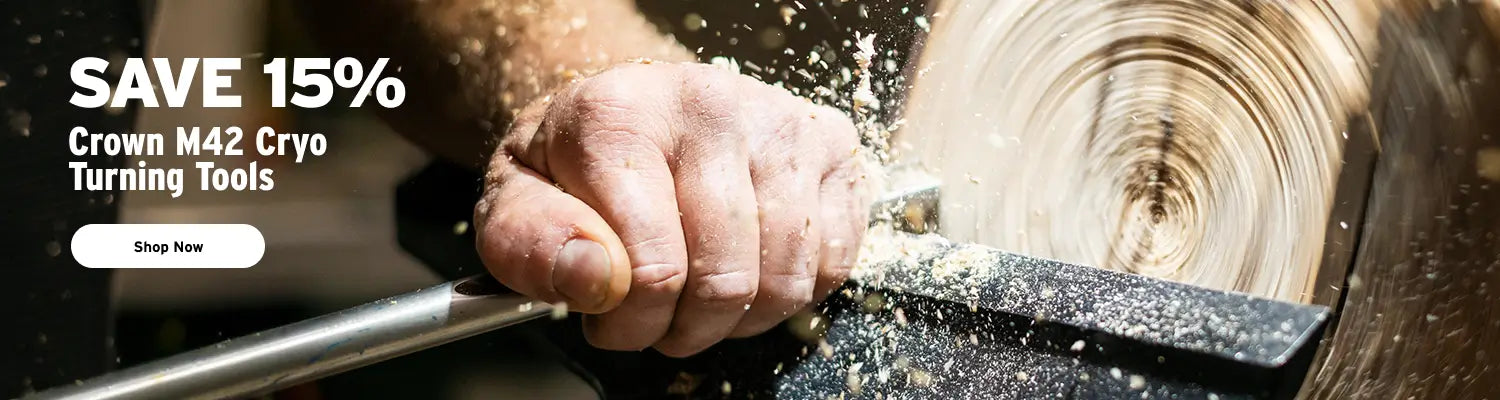 Hand using a tool on a turning lathe with a promotional banner for Crown M42 Cryo Turning Tools.
